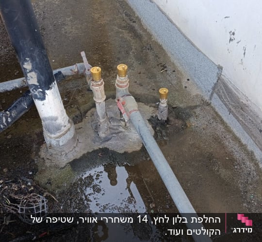 צנרת ומחברים על רצפה רטובה ליד קיר
